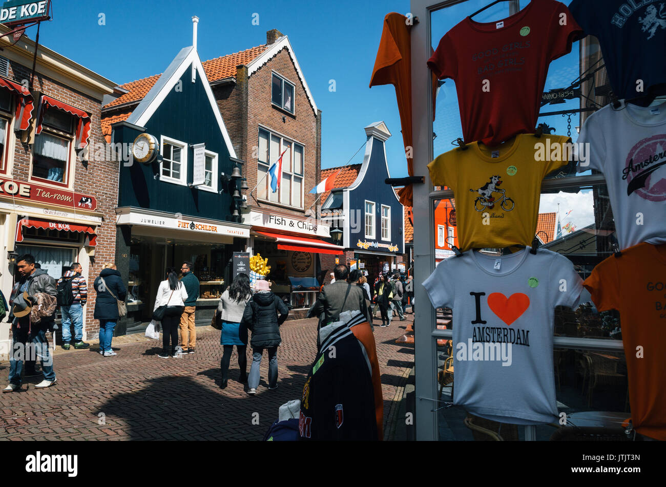 Volendam, Holanda - Abril 26, 2016: Hay turistas que caminan a lo largo de la calle principal de Volendam con cafeterías, tiendas y puestos de venta tradicionales holandeses souve Foto de stock