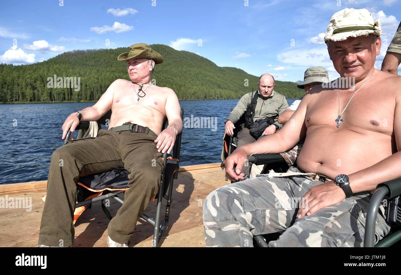 el-presidente-ruso-vladimir-putin-a-la-izquierda-y-el-ministro-de-defensa-sergei-shoigu-relajarse-en-el-sol-descamisados-despues-de-la-pesca-durante-tres-dias-de-pesca-y-caza-de-aventura-en-la-selva-de-siberia-cerca-de-la-frontera-con-mongolia-agosto-1-3-2017-en-la-republica-tyva-rusia-jtm1j8.jpg