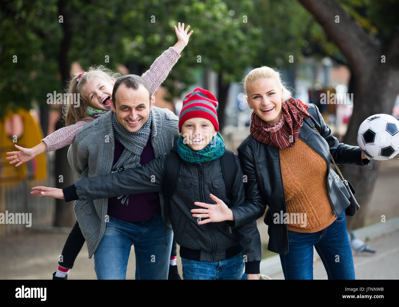 Los cónyuges con hijos americanos felices posando en el parque de otoño y sonriente Foto de stock