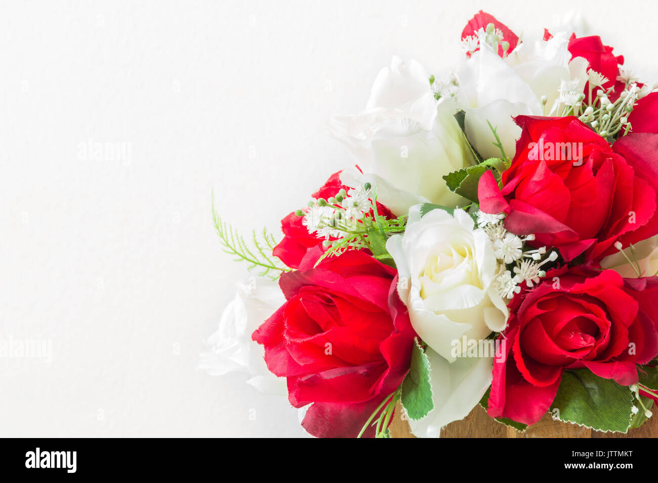 Rosas rojas y rosas blancas sobre un fondo blanco artificial con