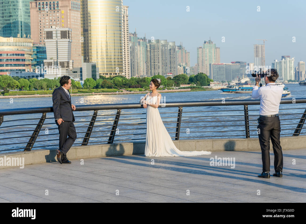 Un par de posar para fotos de bodas en las orillas del río Haungpu en Shanghai, China. Foto de stock