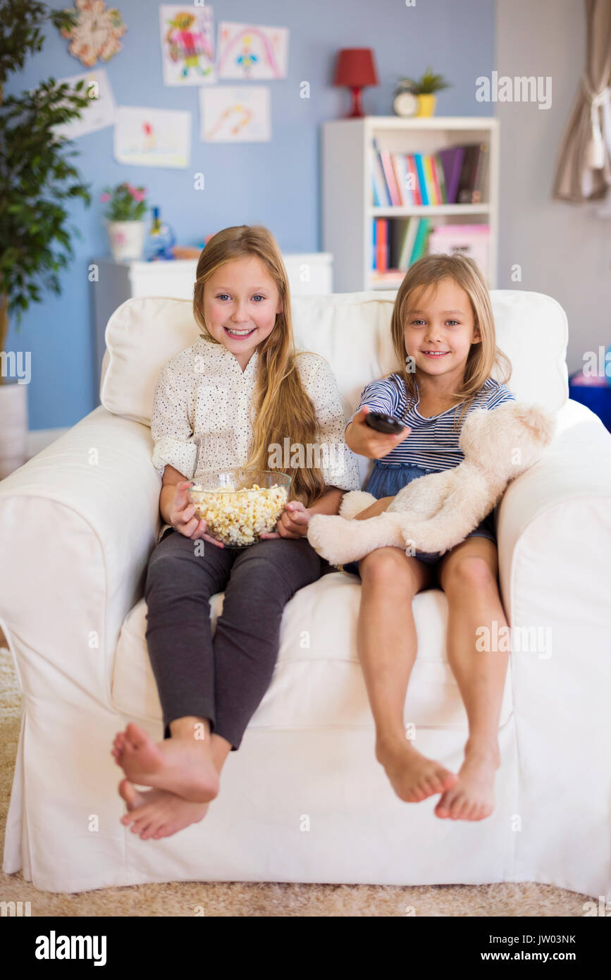 Niñas en edad primaria esperando su programa de TV favorito Foto de stock