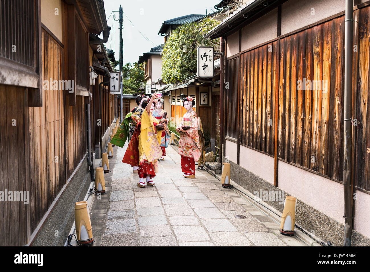 Grupo de cuatro tomando un selfie Geisha en una calle tradicional de Kyoto en Japón Foto de stock