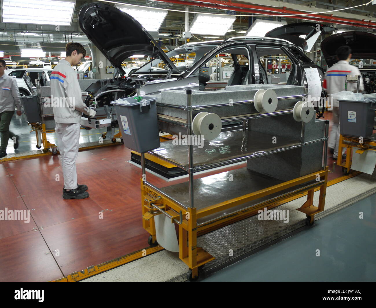 Los trabajadores en la línea de montaje de la planta de producción de automóviles Dongfeng PSA de Chengdu (China) Foto de stock