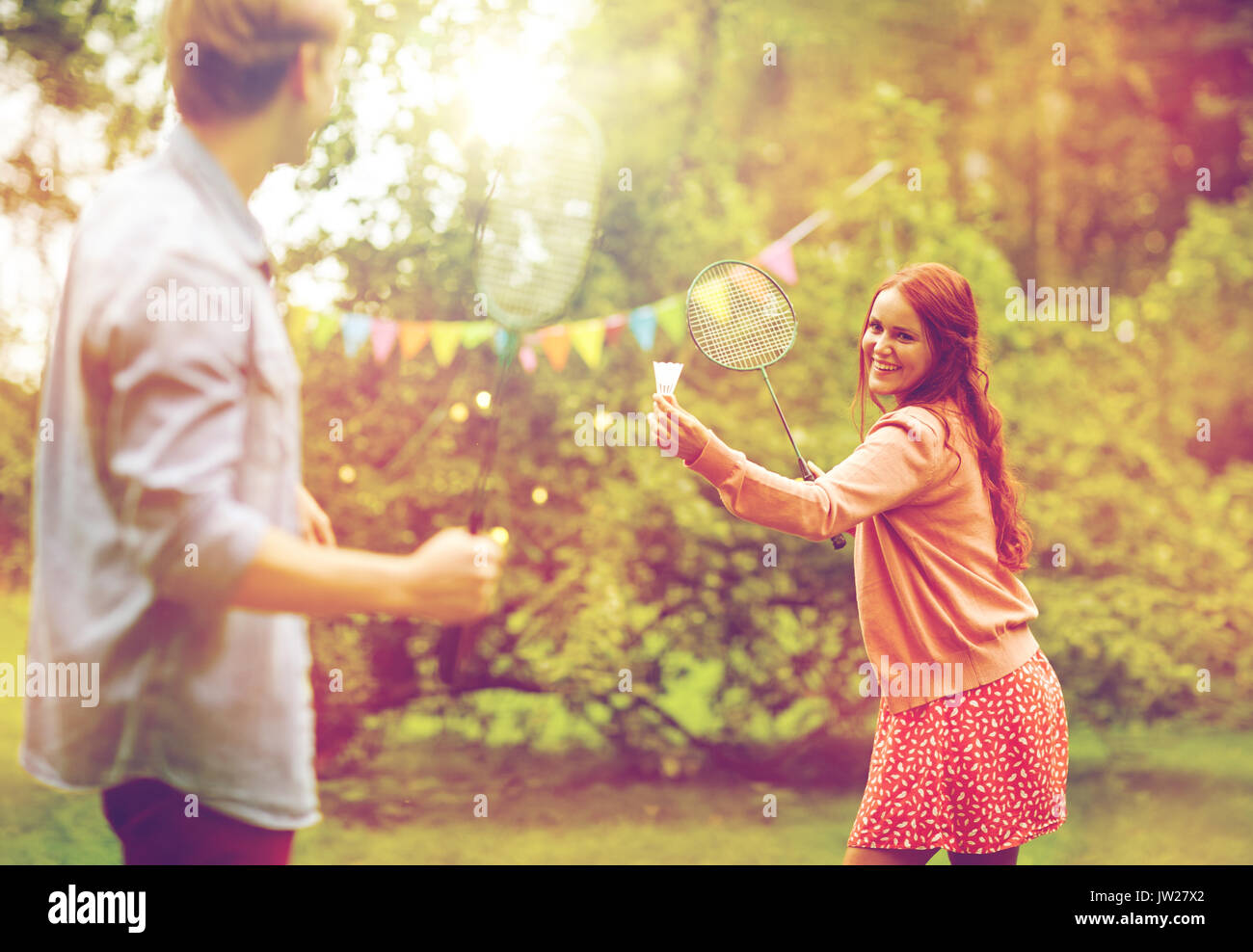 Feliz amigos jugando al bádminton en el jardín de verano Foto de stock