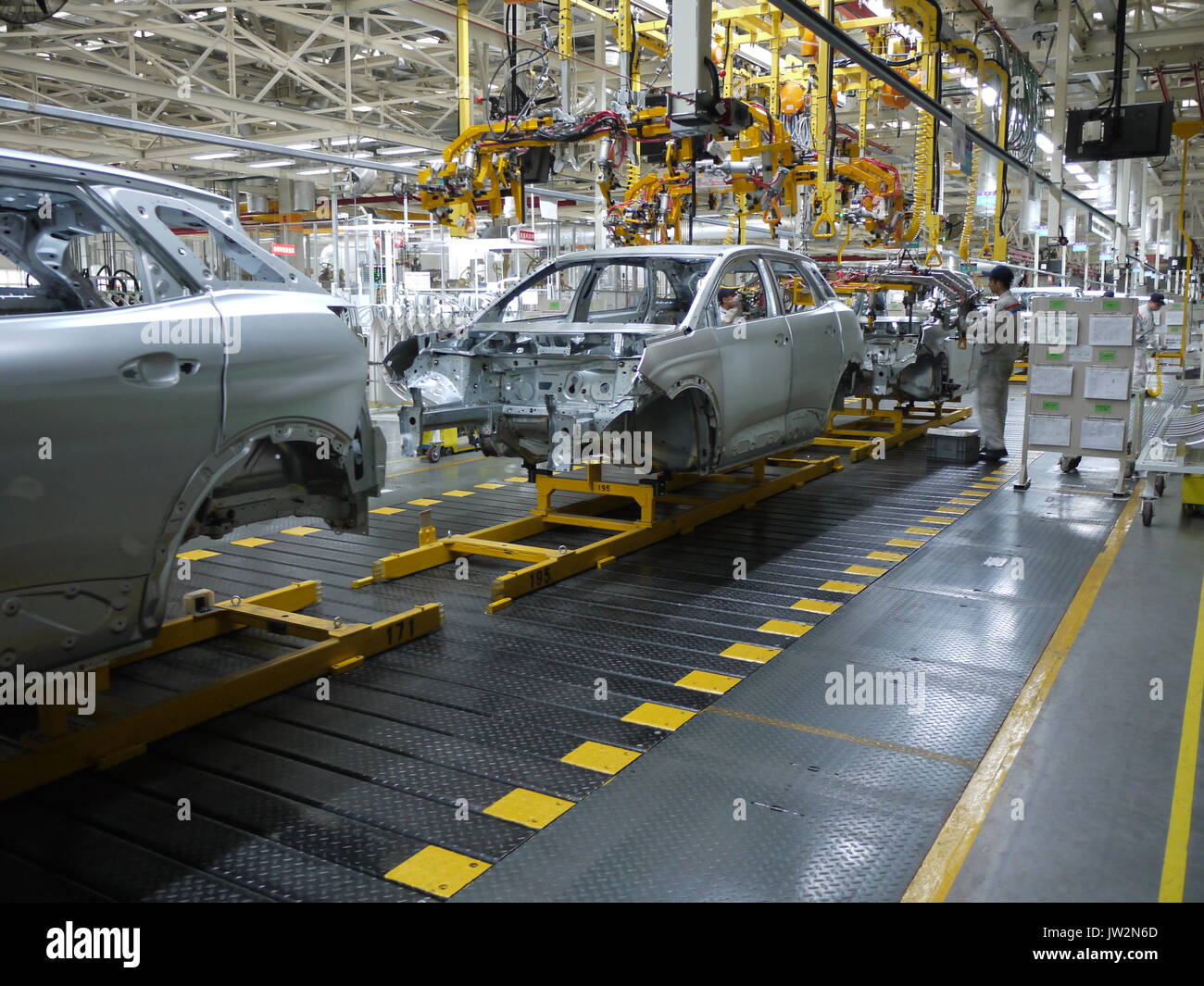 Los trabajadores en la línea de montaje de la planta de producción de automóviles Dongfeng PSA de Chengdu (China) Foto de stock