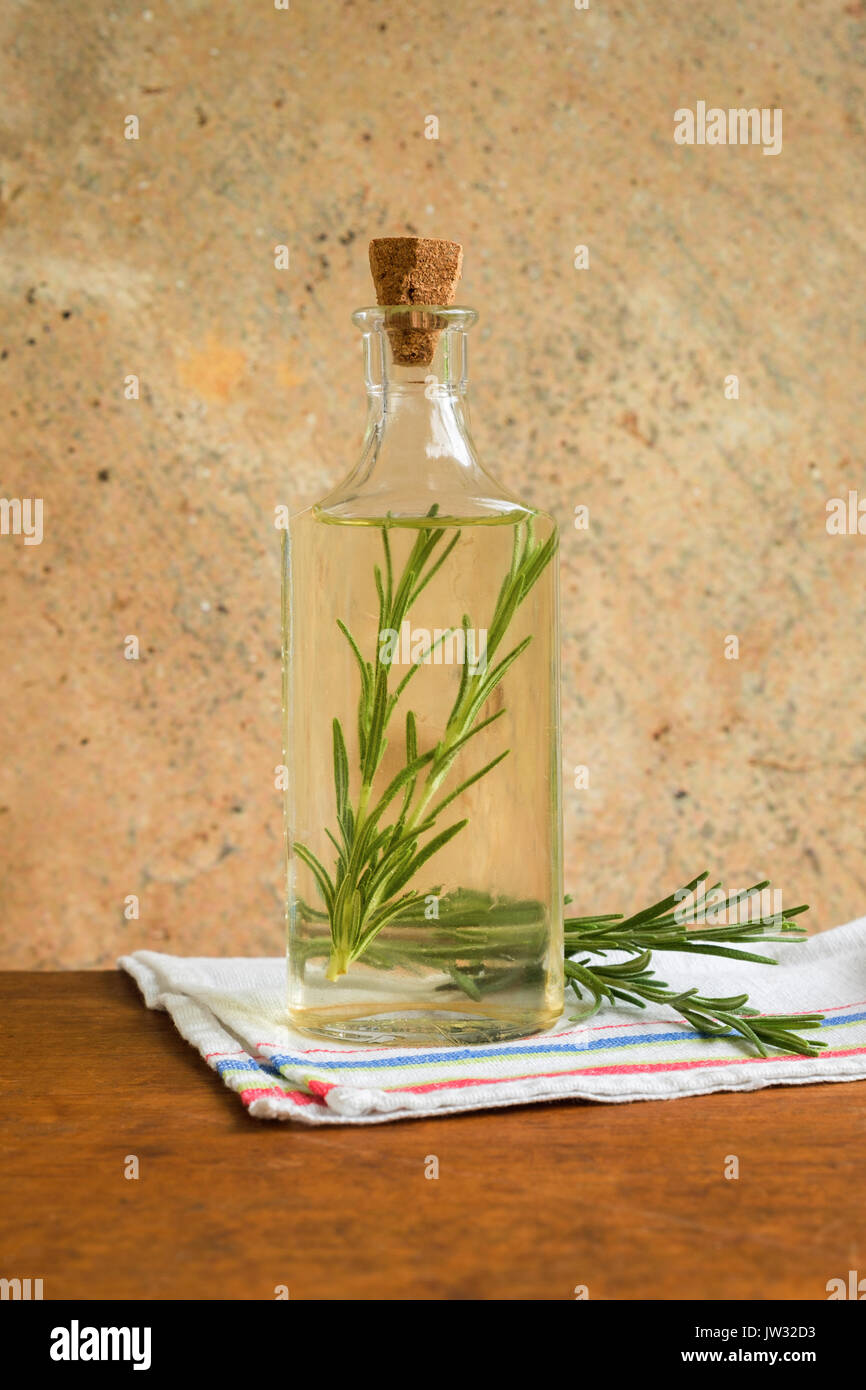 Botella de aceite de oliva con hojas de romero Foto de stock