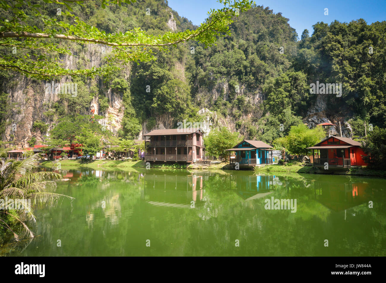 Reflejos de agua de casas de madera con calizas en el fondo en el paisaje de la ciudad de Ipoh, Perak, Malasia. Sudeste asiático Foto de stock