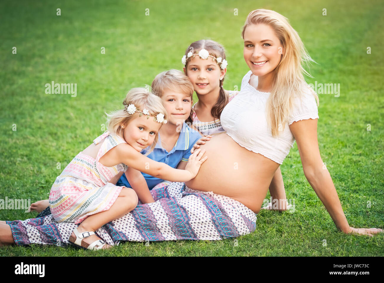 Madre de muchos hijos, lindo rubia embarazada con sus tres hijos mayores  con placer pasar tiempo al aire libre, feliz vida familiar Fotografía de  stock - Alamy