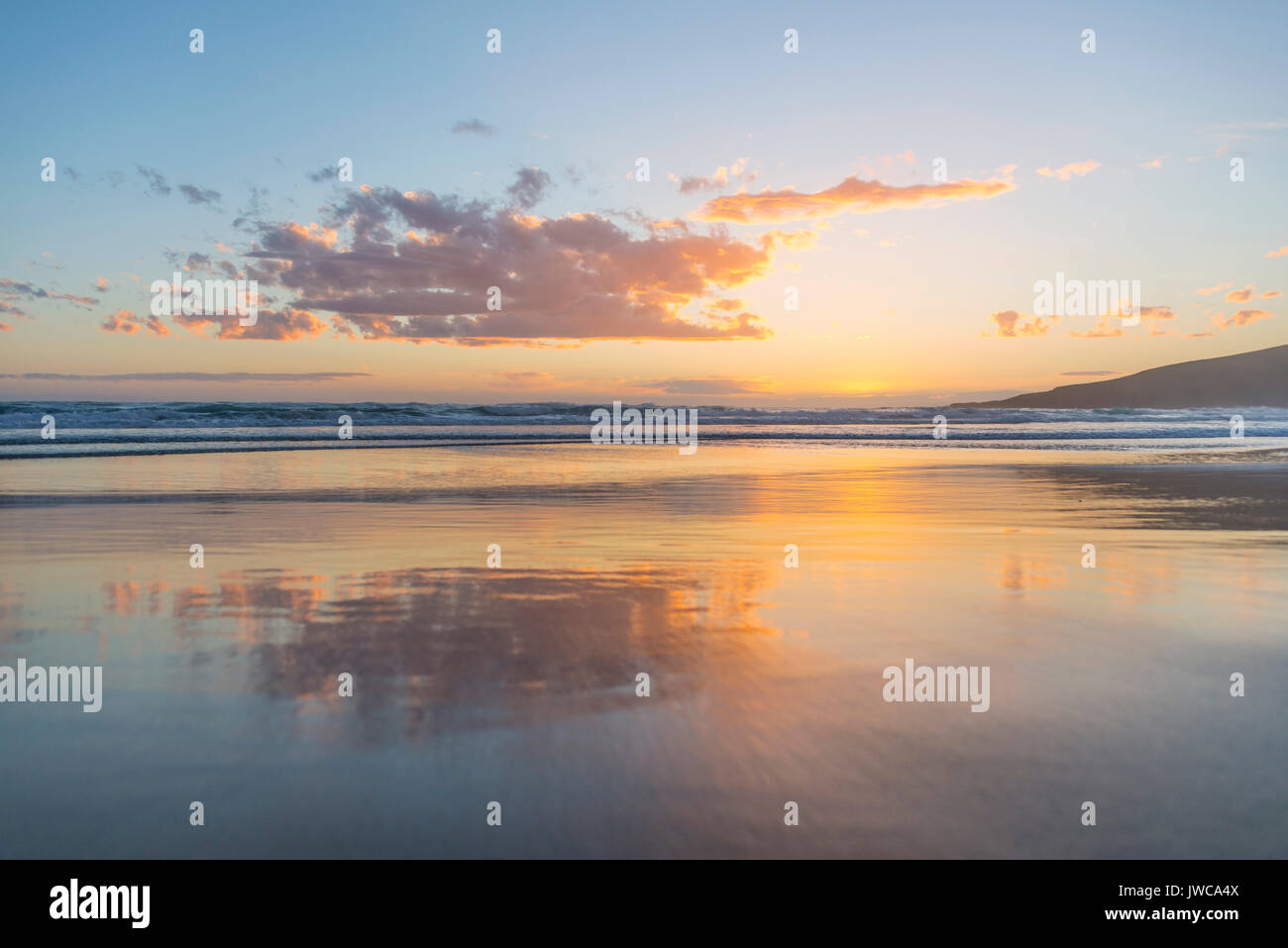 La reflexión, la puesta de sol sobre el mar, el flebótomo, Dunedin, bahía de Otago, Isla del Sur, Nueva Zelanda Foto de stock