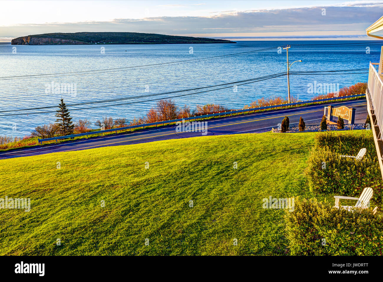 Perce, Canadá - 7 de junio de 2017: la isla Bonaventure durante el amanecer en la península Gaspe, Quebec, Canadá, región Gaspesie con agua azul y hotel firmar Foto de stock