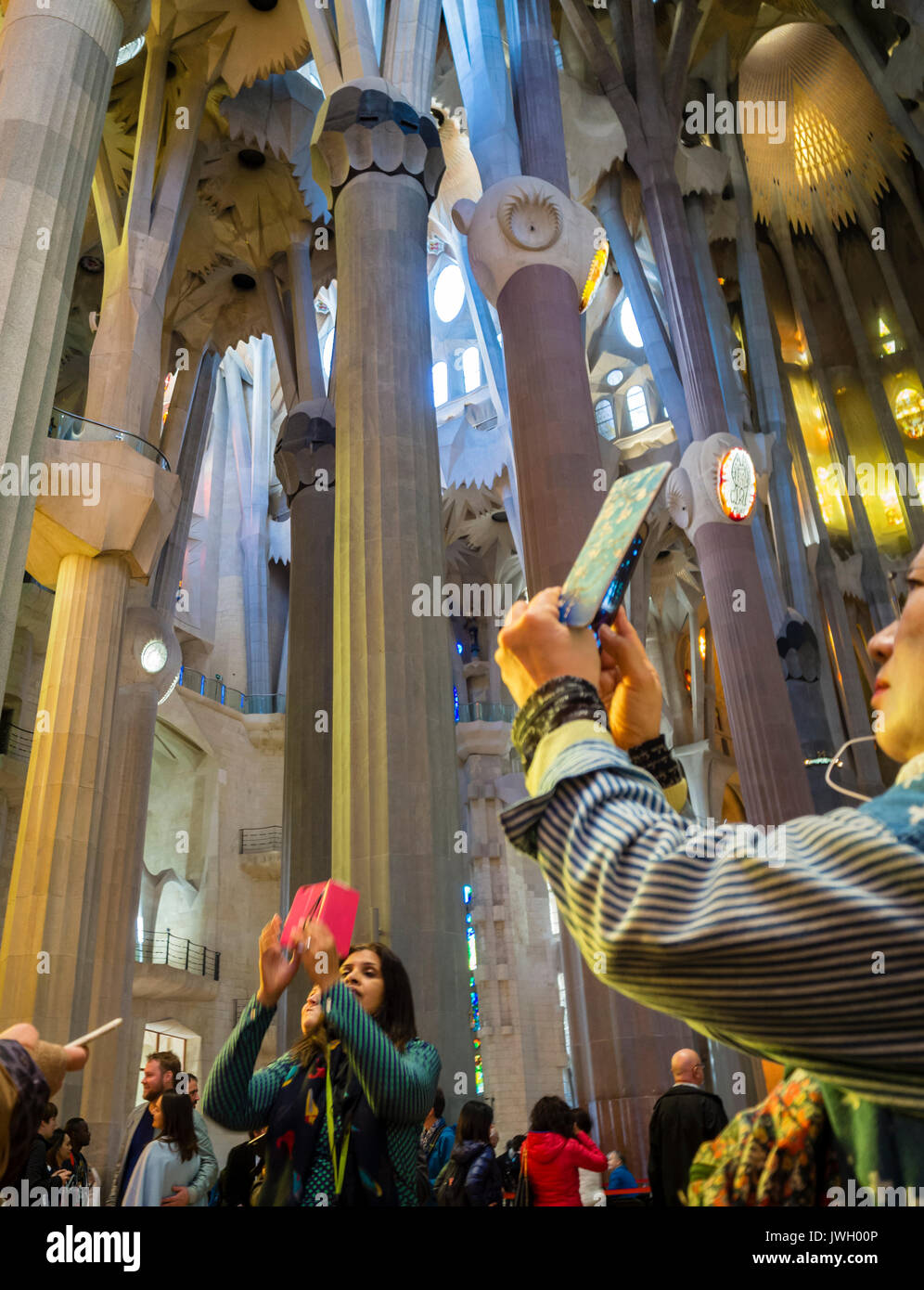 Los turistas están tomando fotos con sus teléfonos inteligentes dentro de Barcelona la catedral de la Sagrada Familia que se llena de visitantes de todo el mundo Foto de stock