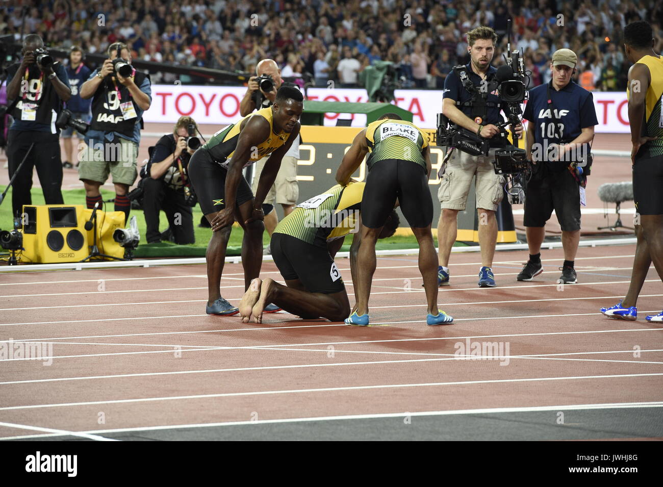 Londres, Reino Unido. 12 Aug, 2017. El atleta jamaicano Usain Bolt se arrodilla en el suelo después de sufrir una lesión mientras compiten en los hombres de 4 x 100 metros relevos carrera en el Campeonato Mundial de la IAAF en Londres, Reino Unido, 12 de agosto de 2017. Foto: Rainer Jensen/dpa/Alamy Live News Foto de stock