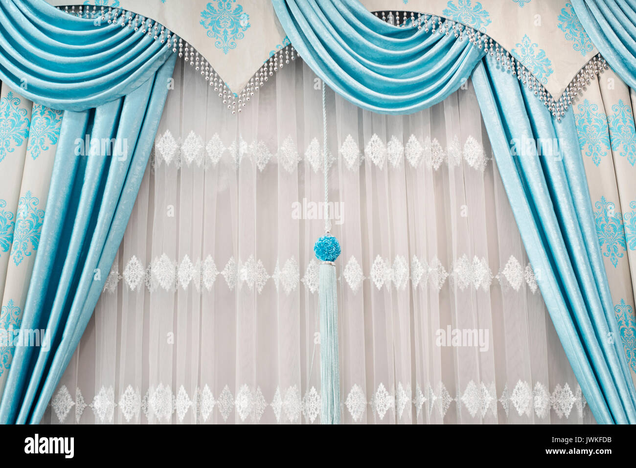 Parte de bellamente vestidas cortina en la ventana de la habitación. Cierre  de cortina con cortinas colgantes. Cortina de lujo, la decoración del  hogar. Turquesa y azul Fotografía de stock - Alamy