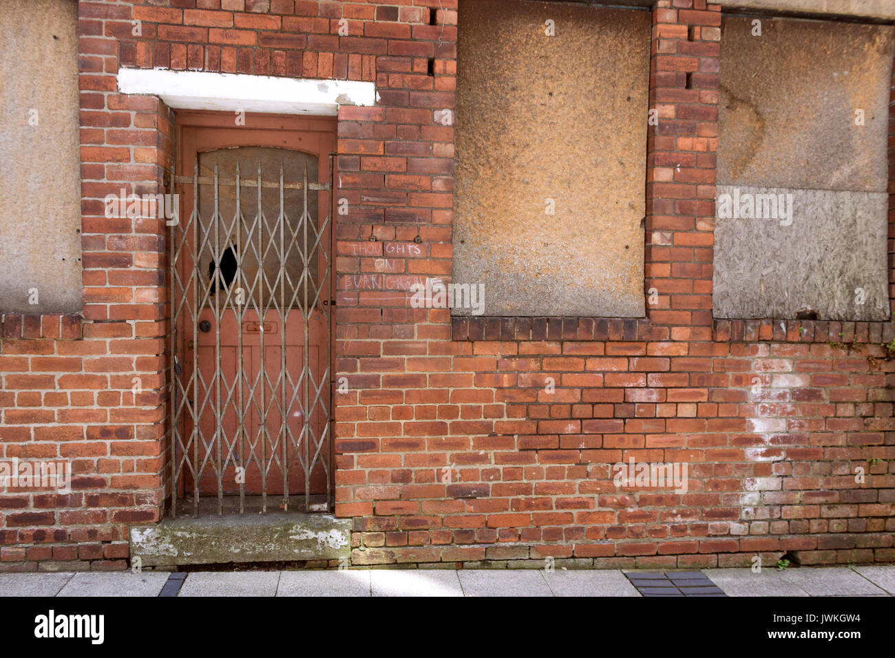Edificio abandonado, con ventanas, barricadas, puerta de hierro, ventana rota, área urbana, sellado, ladrillo exterior, cierre, asegurado Foto de stock