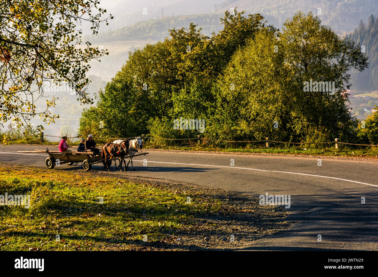 Volovets, Ucrania - 30 Sep, 2016: familia gitana a caballo, carro de serpentine en área rural. brillante amanecer otoñal en Cárpatos Foto de stock