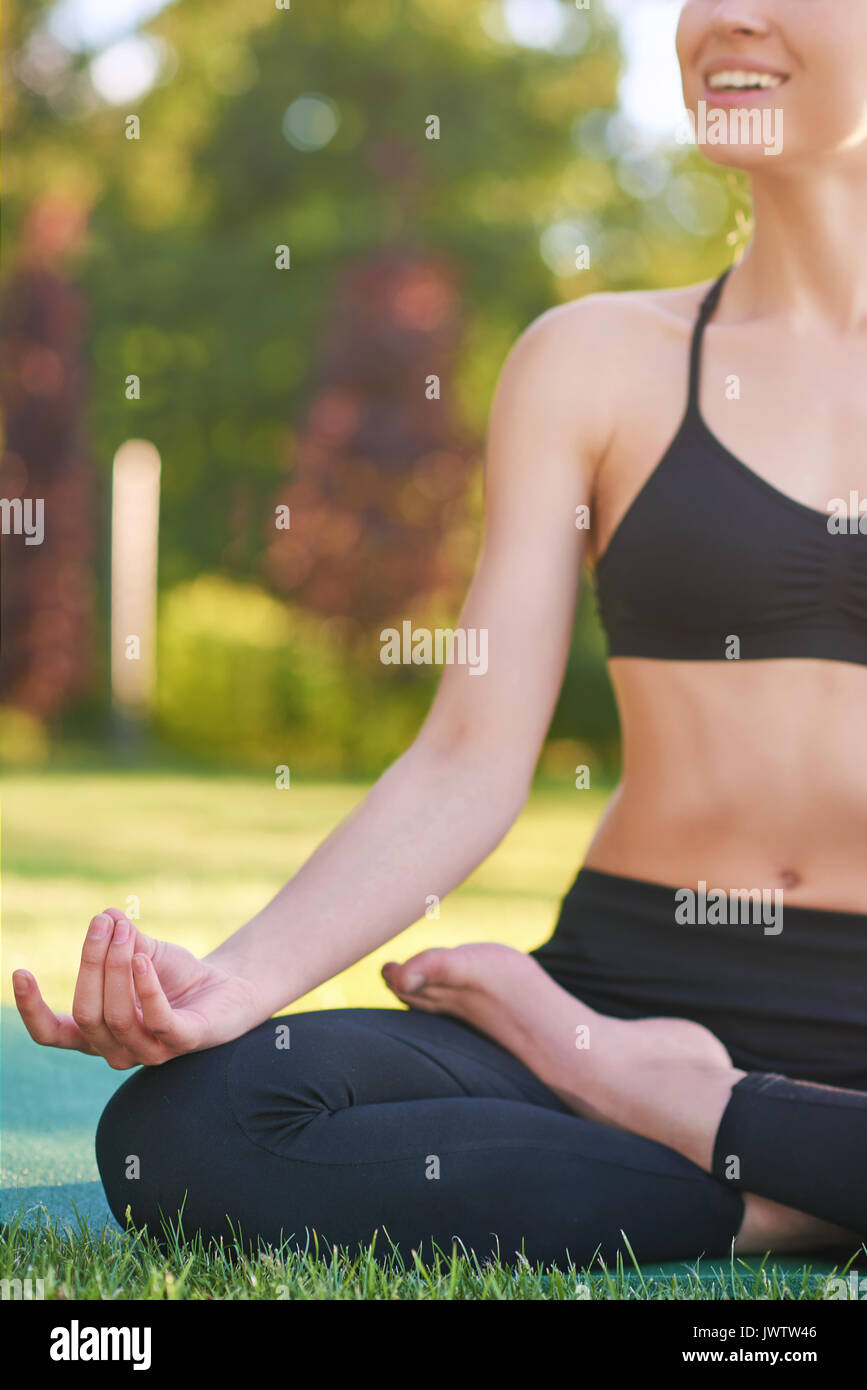 Mujer joven practicando yoga al aire libre en el parque Foto de stock