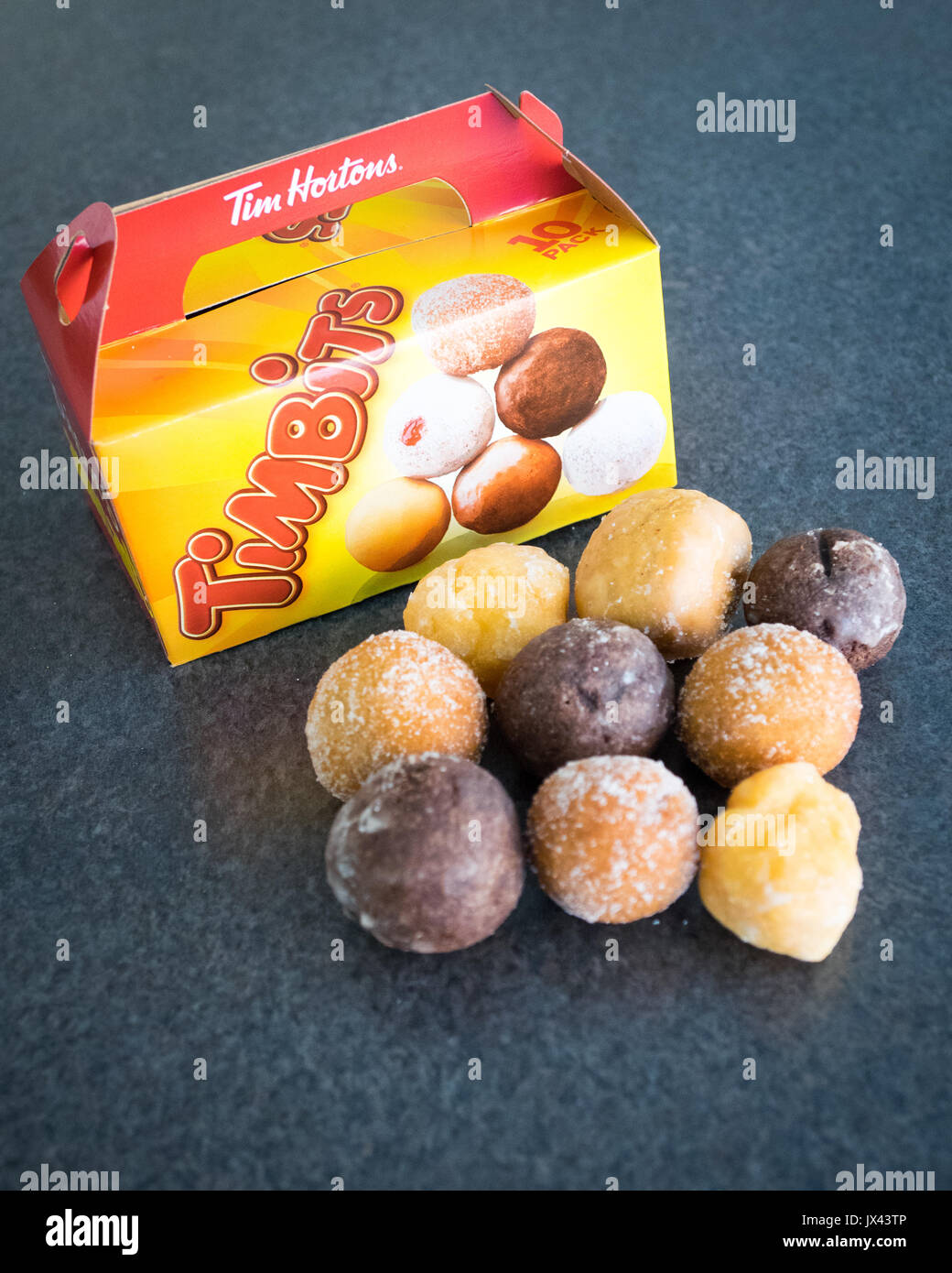 Timbits (agujeros de donut, donut agujeros) de Tim Hortons, una conocida cadena de restaurantes de comida rápida de Canadá. Foto de stock