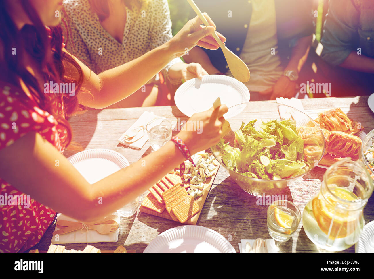 Feliz amigos cenando en la fiesta de verano Foto de stock