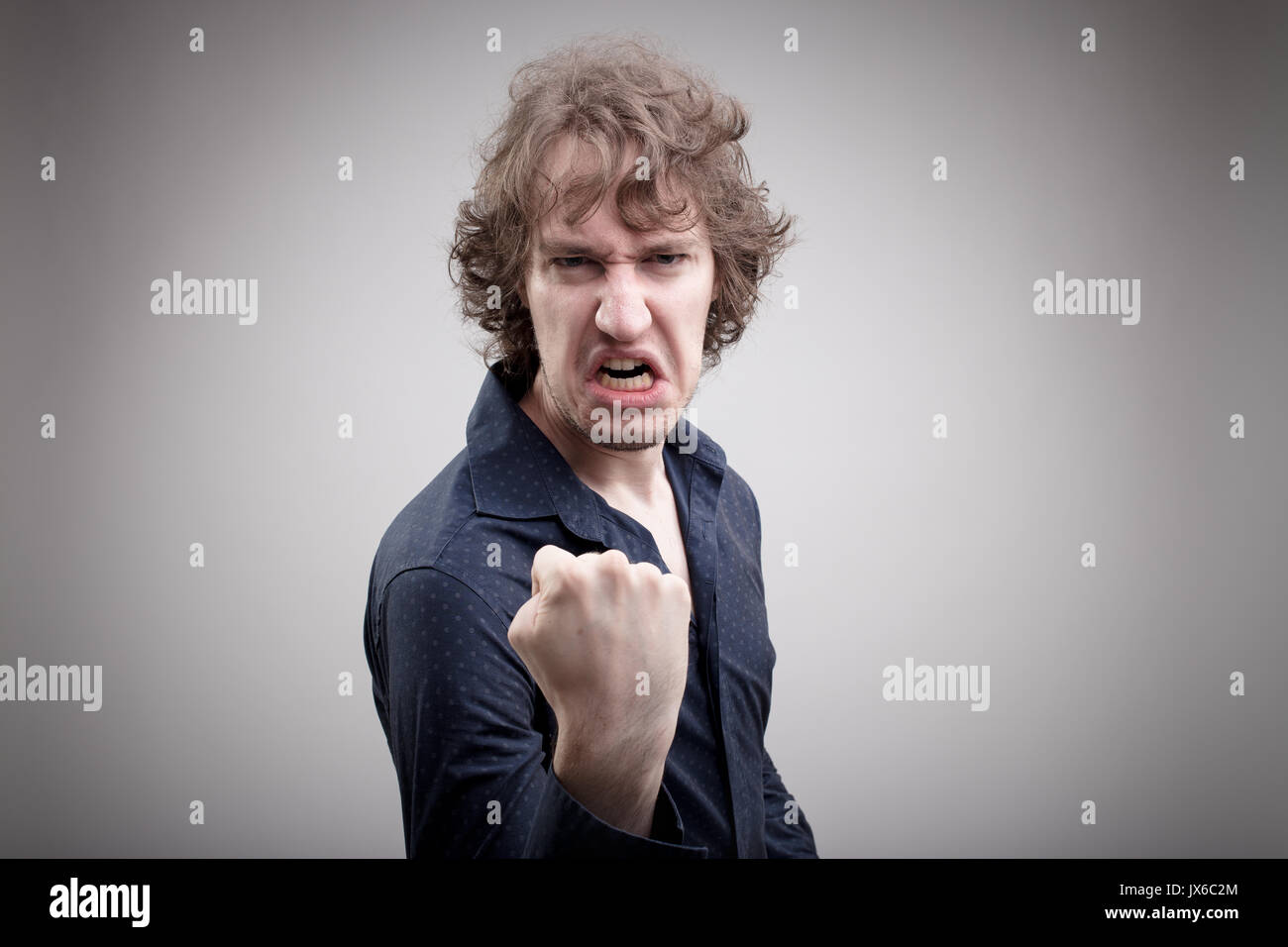 El hombre enojado tratando de intimidar a usted con una grave amenaza con su punzón Foto de stock