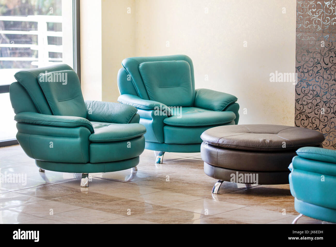 Modernos y confortables sillones de cuero de lujo y mesa redonda en una  sala o área de espera de un edificio comercial Fotografía de stock - Alamy