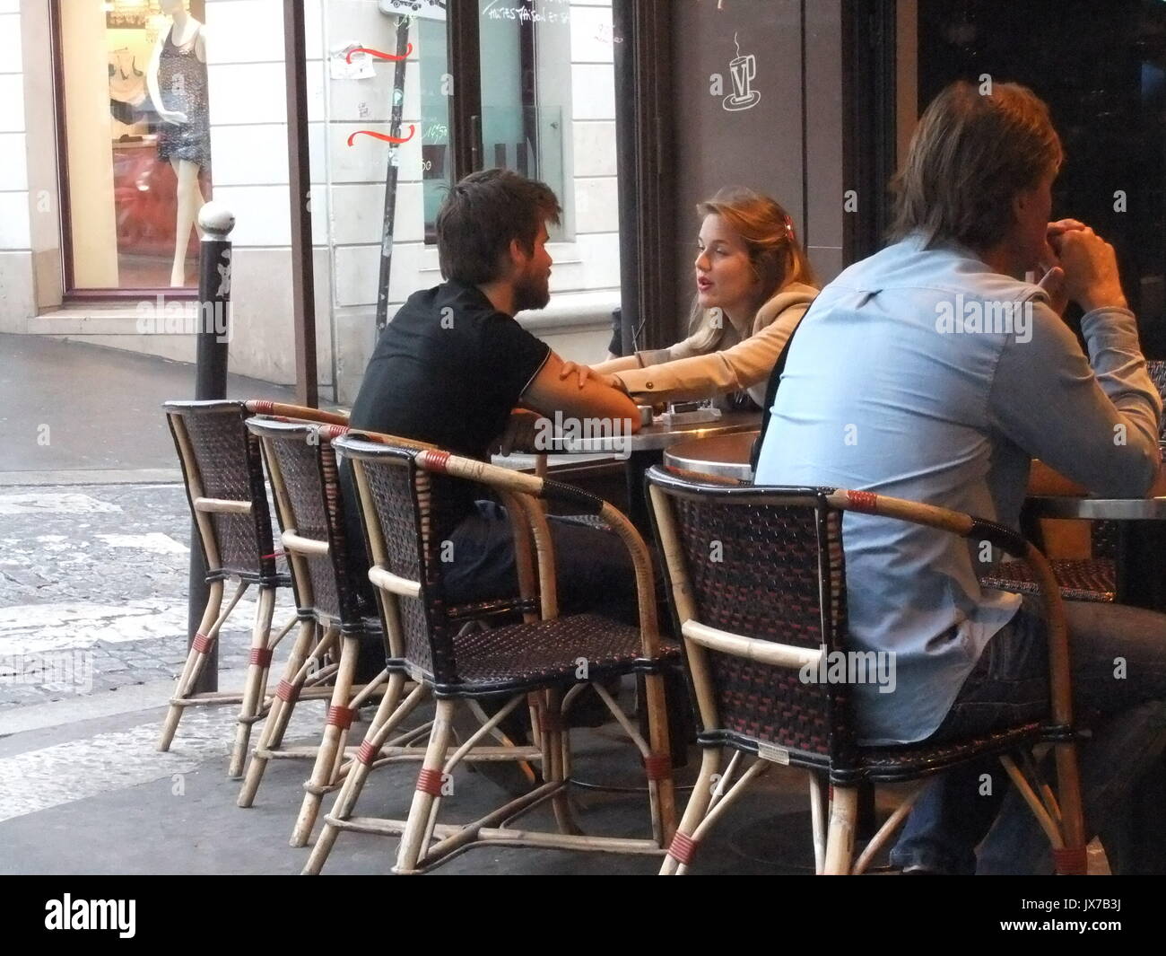 Un momento intenso entre una pareja romántica en un pavimento café en Montmartre, París Foto de stock