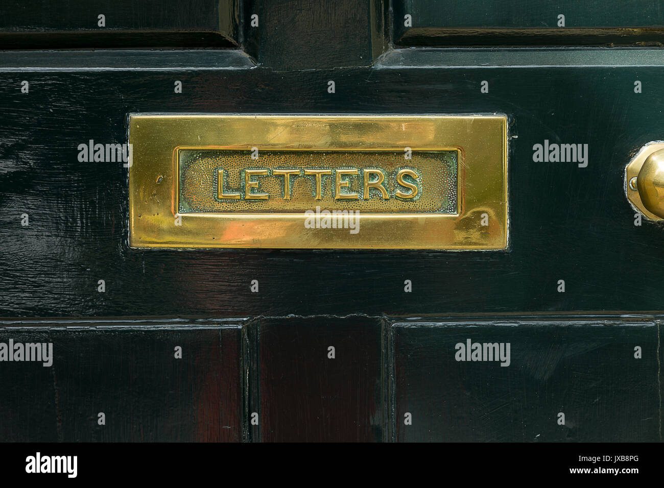 Latón Letterbox, puerta negra Foto de stock