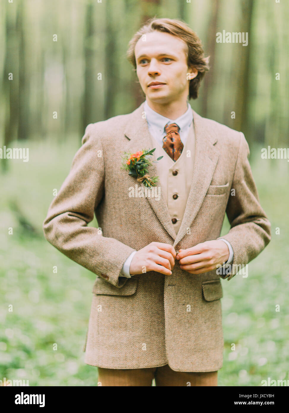 El retrato del hombre rubio guapo en el traje vintage es abotonarse hir  chaqueta decorada con mini-bouquet Fotografía de stock - Alamy