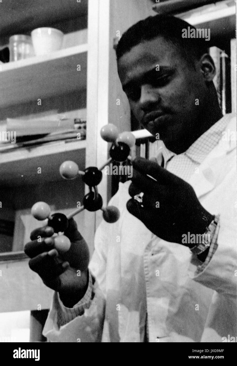 Ernest un Bates, los estudiantes afroamericanos, retrato, de pie, pecho, tres cuartos vista, CA de 22 años de edad, Bates es la celebración de un modelo molecular en el laboratorio, 1958. Foto de stock