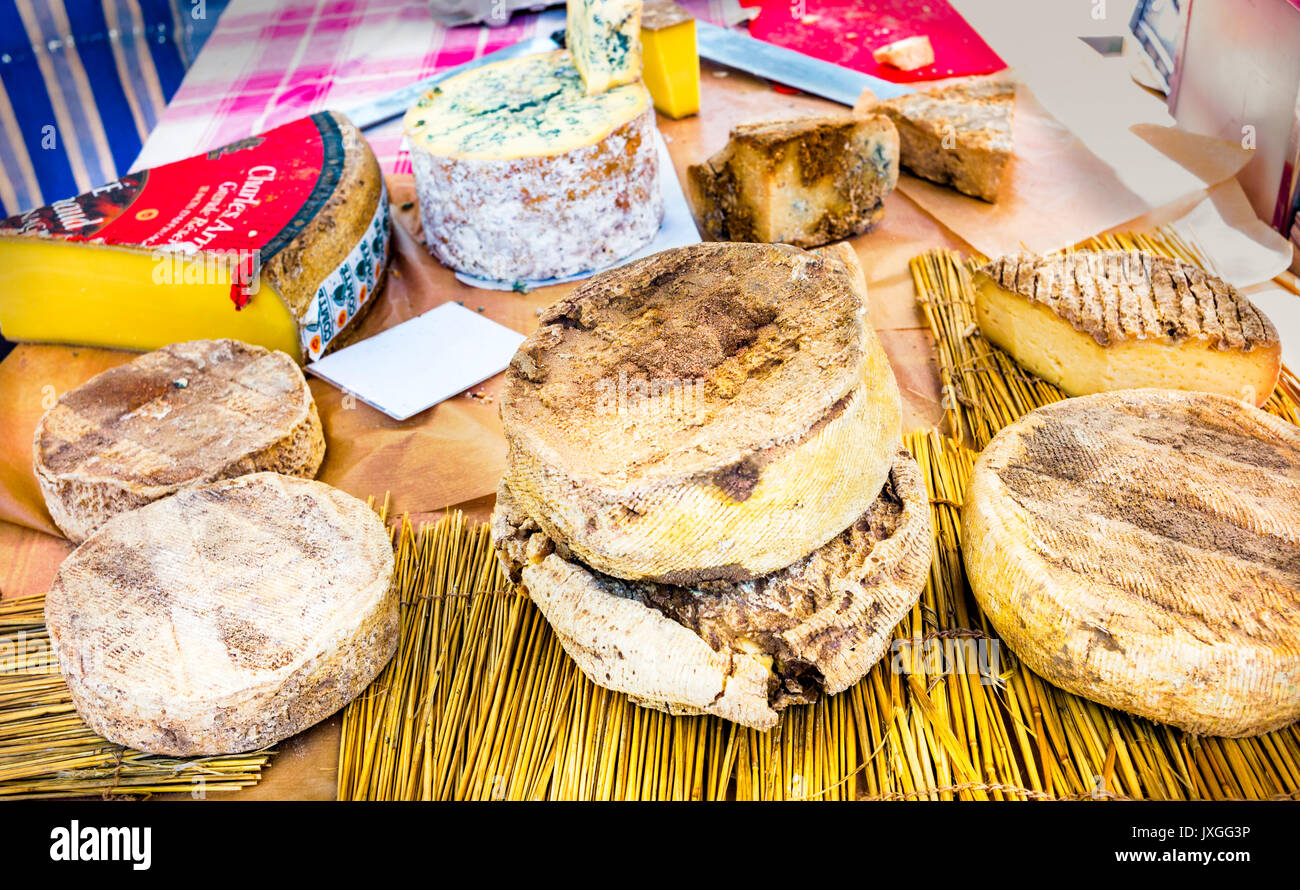 Tabla rústica de quesos franceses en un mercado de París, Francia