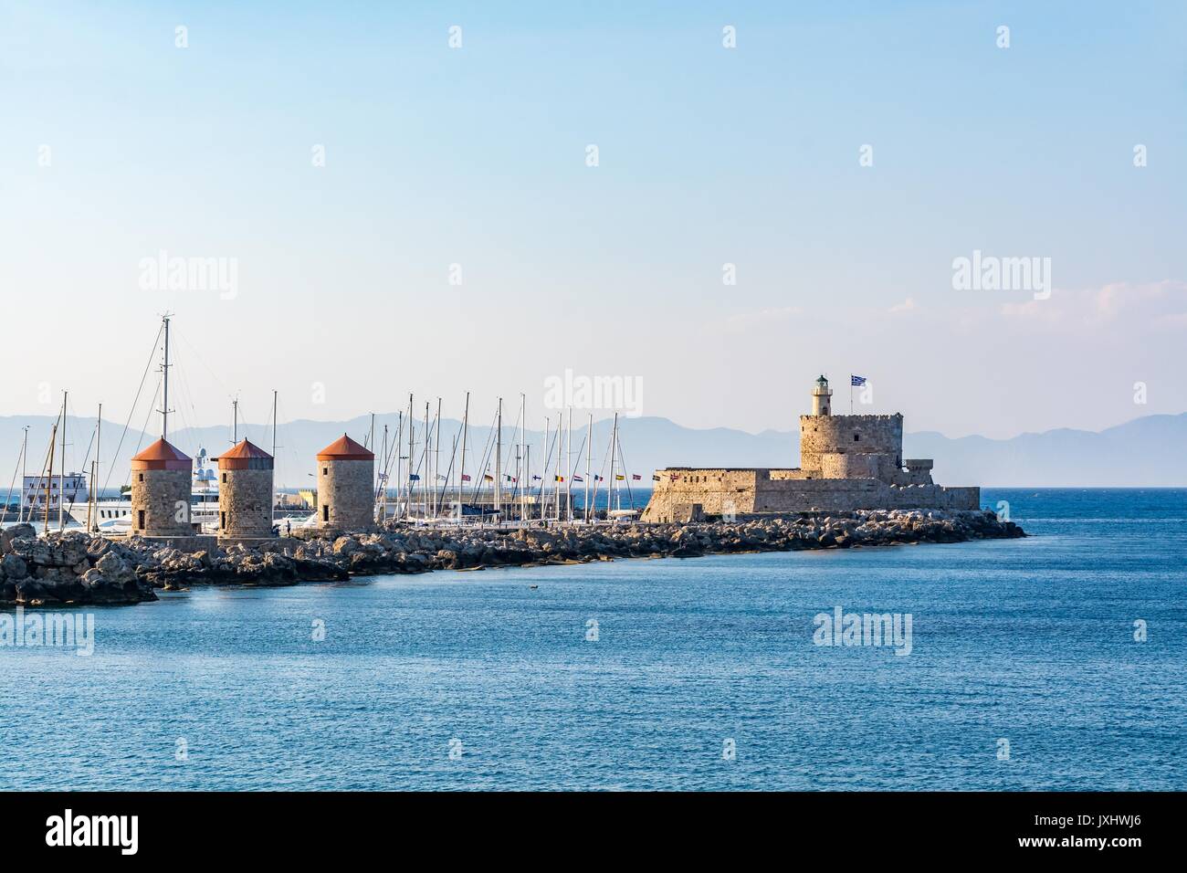 Agios Nikolaos Fort (Fuerte de San Nicolás) y molinos, a la entrada del puerto de Mandraki, la isla de Rodas, Grecia Foto de stock