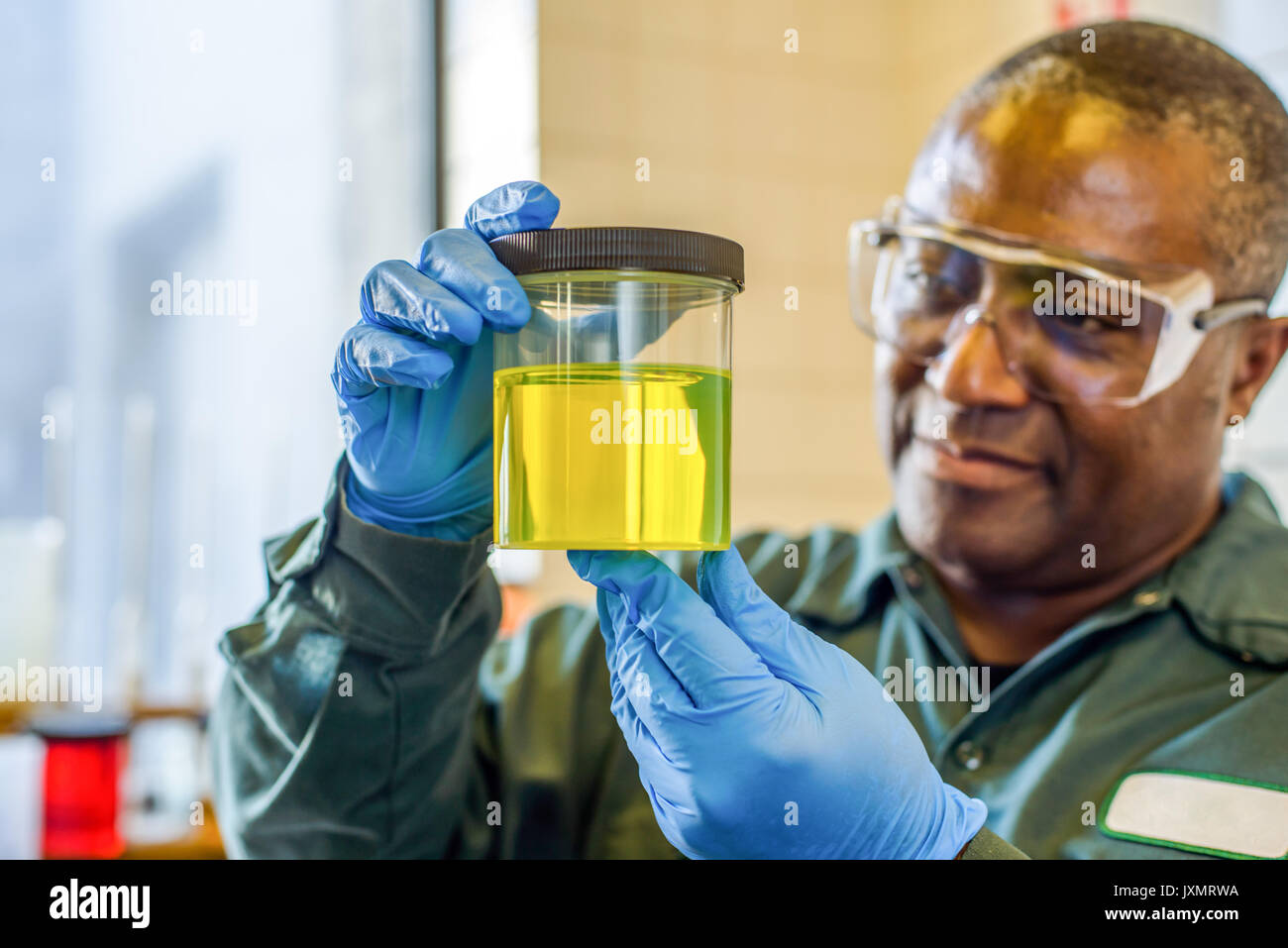 Técnico de laboratorio mirando el vaso de amarillo en biocombustibles biocombustibles laboratorio de planta Foto de stock