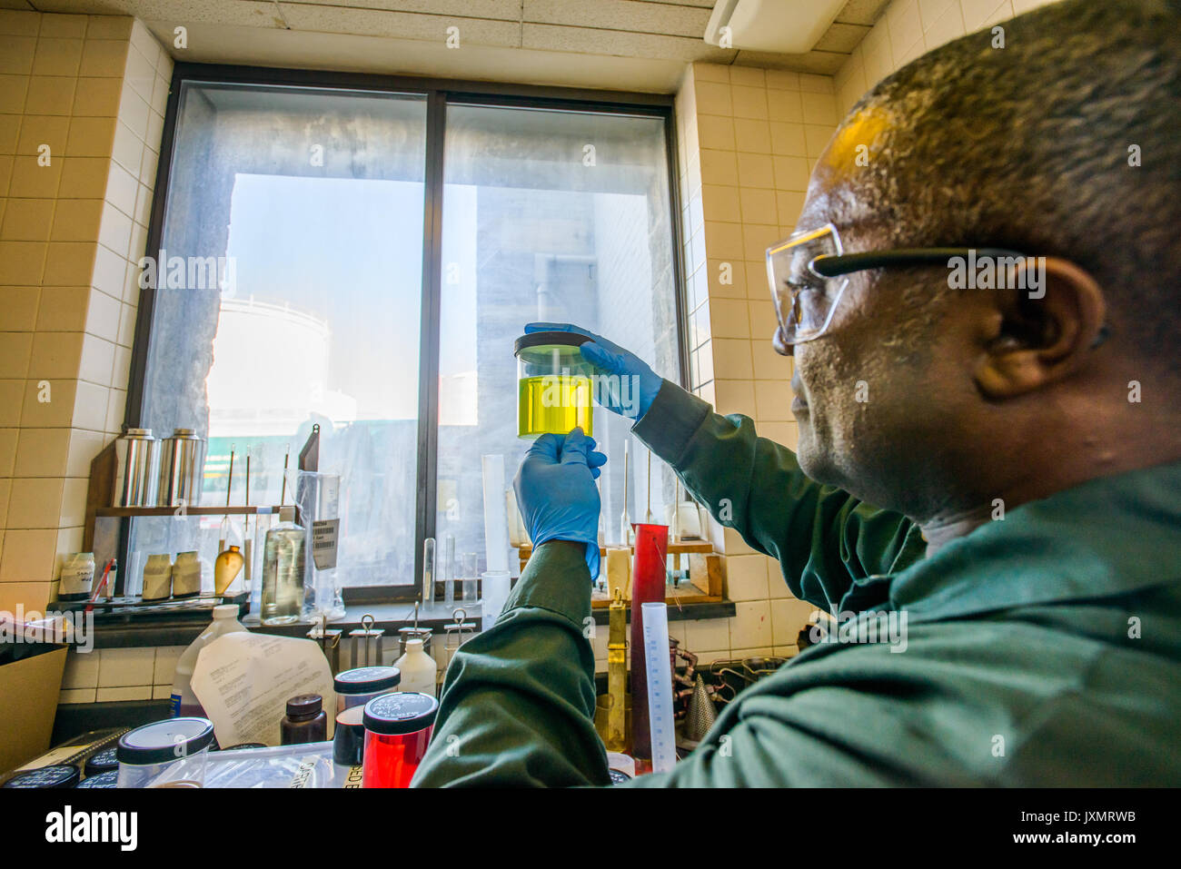 Técnico de laboratorio mirando el vaso de amarillo en biocombustibles biocombustibles laboratorio de planta Foto de stock
