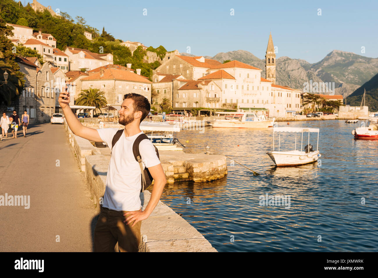 Hombre por Harbour tomando selfie, Perast, Montenegro, Europa Foto de stock