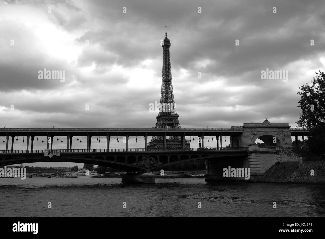 La Torre Eiffel de París, como se ve desde el río Sena en un viaje en barco fotografiado en blanco y negro Foto de stock