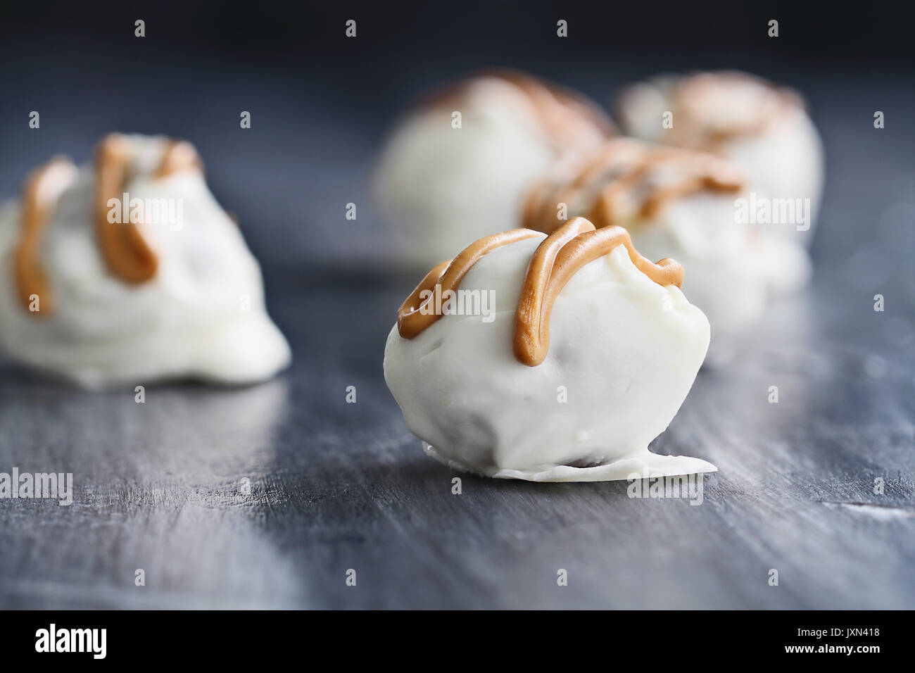 Trufas de chocolate blanco para Navidad o San Valentín aderezada con salsa de mantequilla de maní. Profundidad de campo extremas con el enfoque selectivo en c Foto de stock