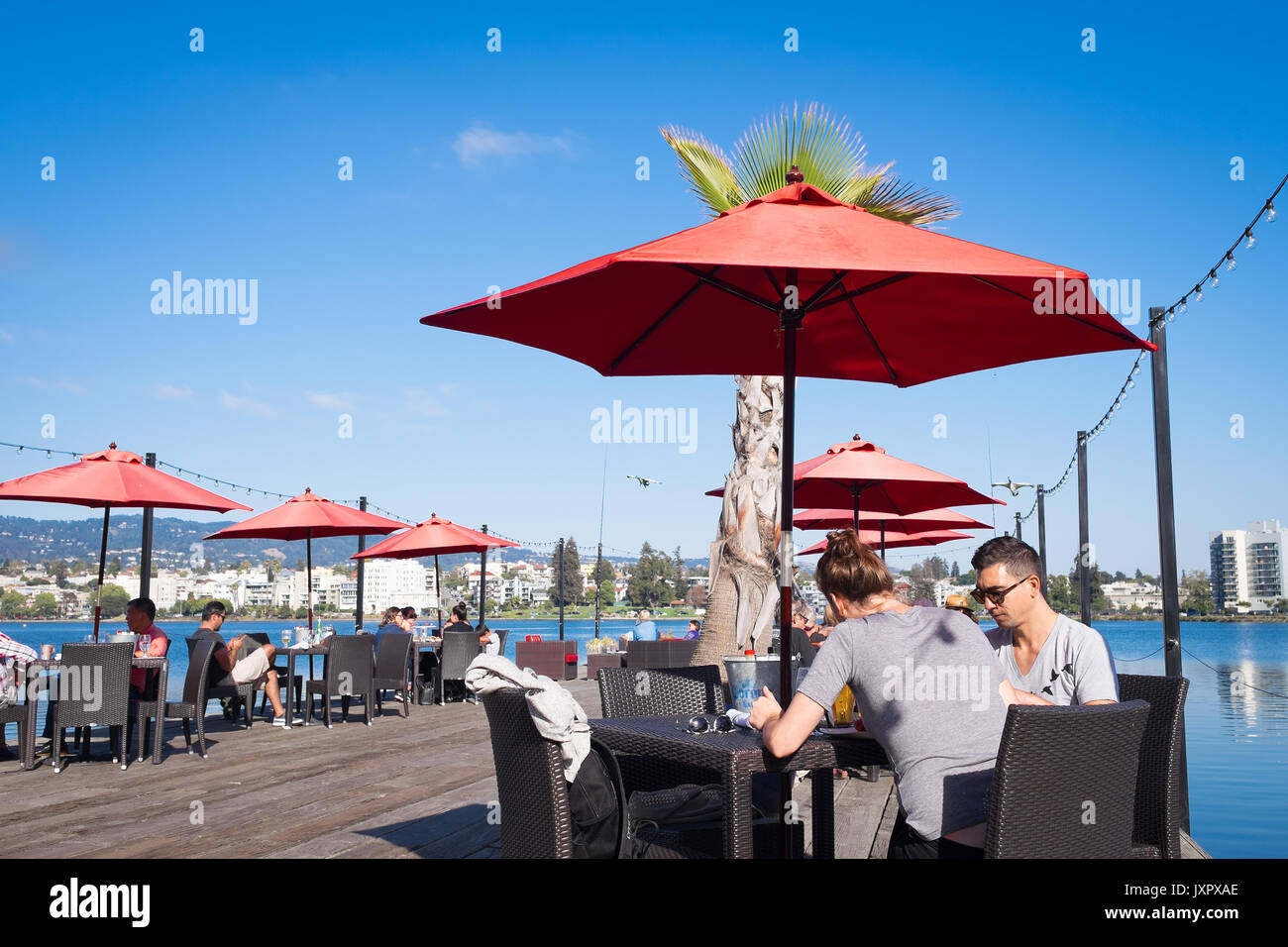 OAKLAND, CA - Agosto 25, 2016: el centro de Lake Merritt restaurante con asientos al aire libre en un muelle de madera. Los comensales disfrutan el brunch de los domingos. Foto de stock