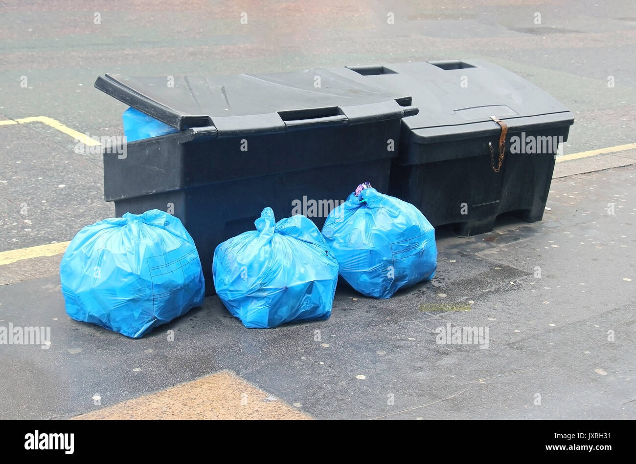 Bolsas de basura azul cerrada con residuos para reciclar en la calle junto  a los cubos de basura Fotografía de stock - Alamy