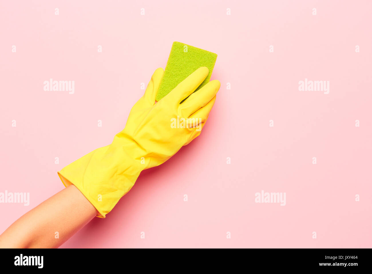 La limpieza de las manos de la mujer sobre un fondo de color rosa. La limpieza o el concepto de limpieza Foto de stock