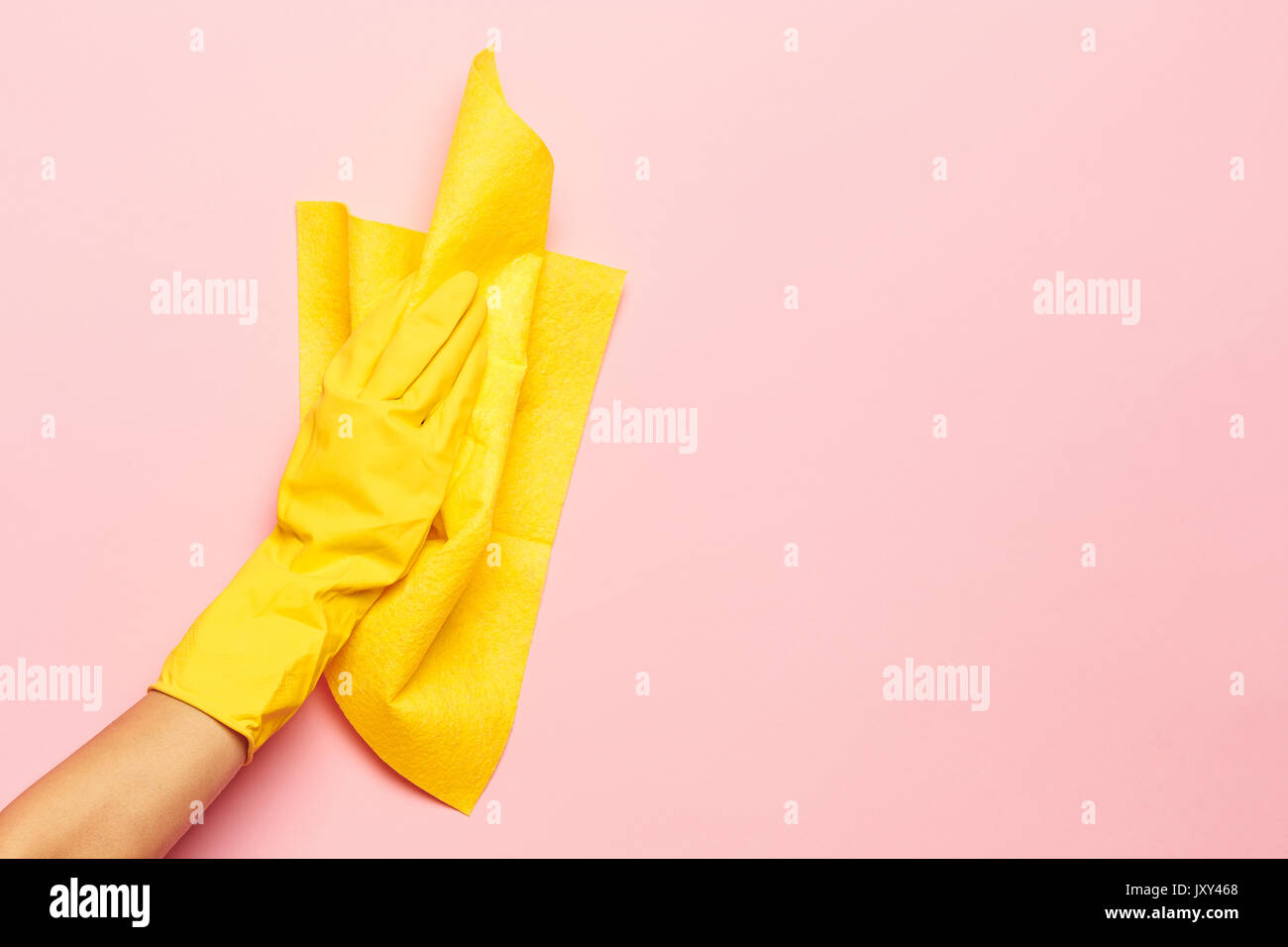 La limpieza de las manos de la mujer sobre un fondo de color rosa. La limpieza o el concepto de limpieza Foto de stock
