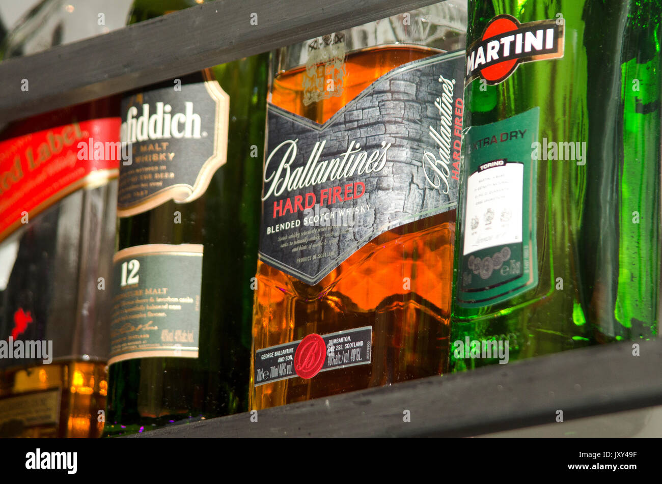 Varias botellas de alcohol en la pantalla en un bar. Foto de stock