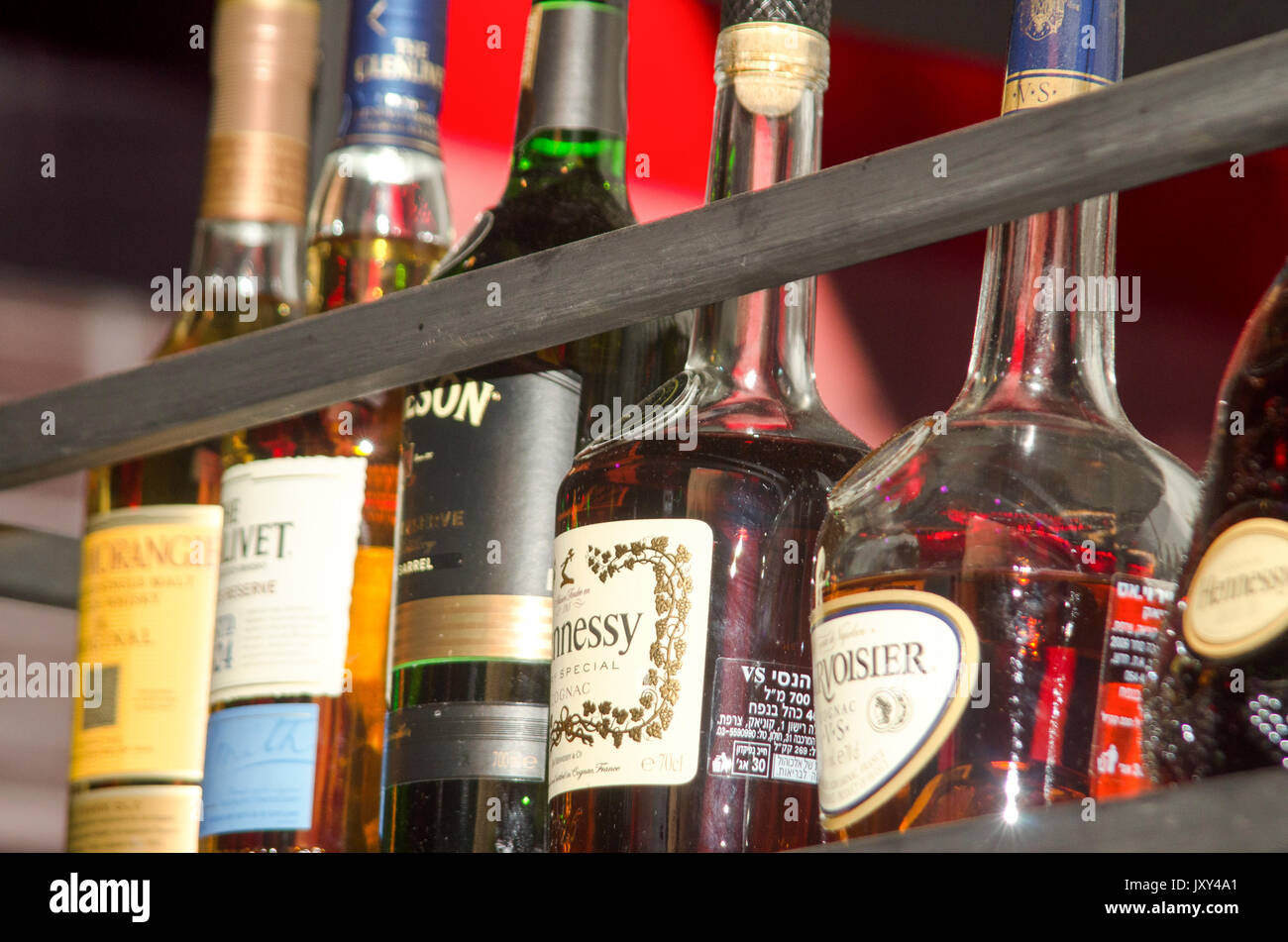 Varias botellas de alcohol en la pantalla en un bar. Foto de stock