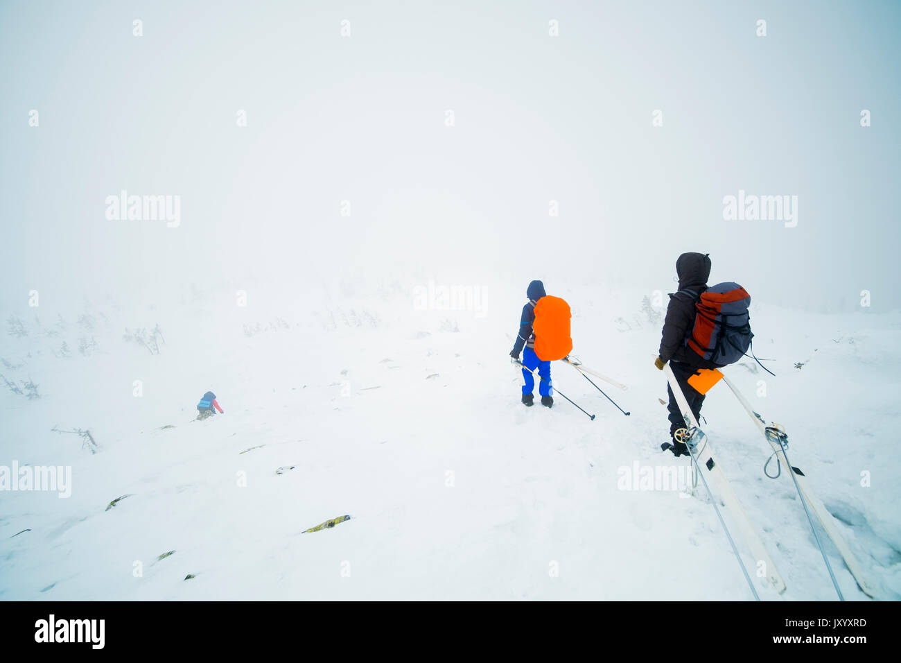 Excursionistas caucásica llevar los esquís en la montaña Foto de stock