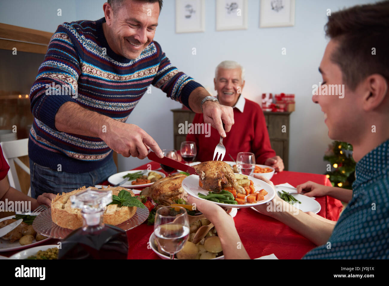 Padre sirve cenas en la víspera de Navidad Foto de stock