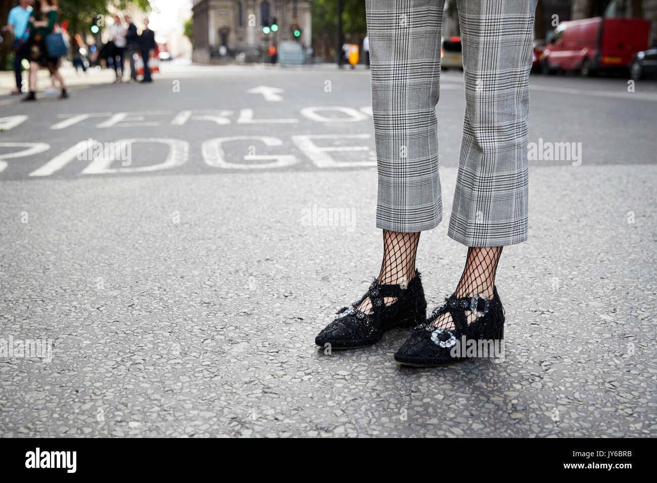 Mujer en fishnets, chequeo de pantalones y zapatos negros, detalle Foto de stock