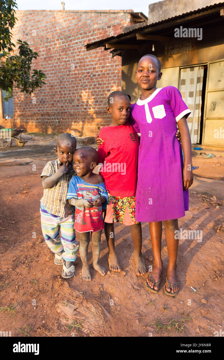 Un grupo de niños africanos smilng, metido juntos en aras de la fotografía. Los niños están en la parte delantera de un cobertizo de madera simple, son probabl Foto de stock