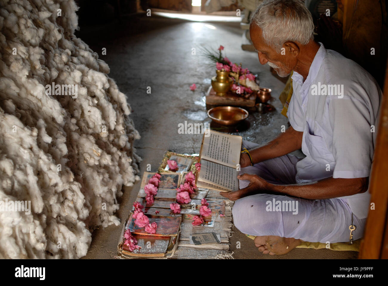 La India de Madhya Pradesh , proyecto de algodón orgánico bioRe en Kasrawad , algodón agricultor tener una oración al lado de su rendimiento de algodón en casa / INDIEN Madhya Pradesh , bioRe Projekt fuer biodynamischen Anbau von Baumwolle en Kasrawad, Baumwollfarmer bei einem Gebet neben cerquero Baumwollernte zu Hause Foto de stock