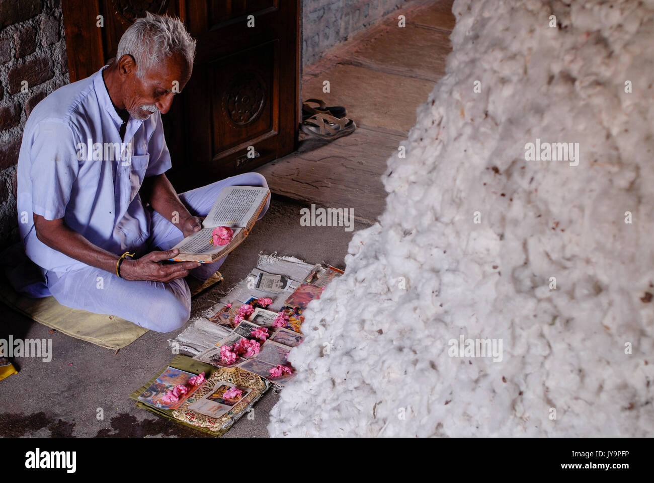 La India de Madhya Pradesh , proyecto de algodón orgánico bioRe en Kasrawad , algodón agricultor tener una oración al lado de su rendimiento de algodón en casa / INDIEN Madhya Pradesh , bioRe Projekt fuer biodynamischen Anbau von Baumwolle en Kasrawad, Baumwollfarmer bei einem Gebet neben cerquero Baumwollernte zu Hause Foto de stock