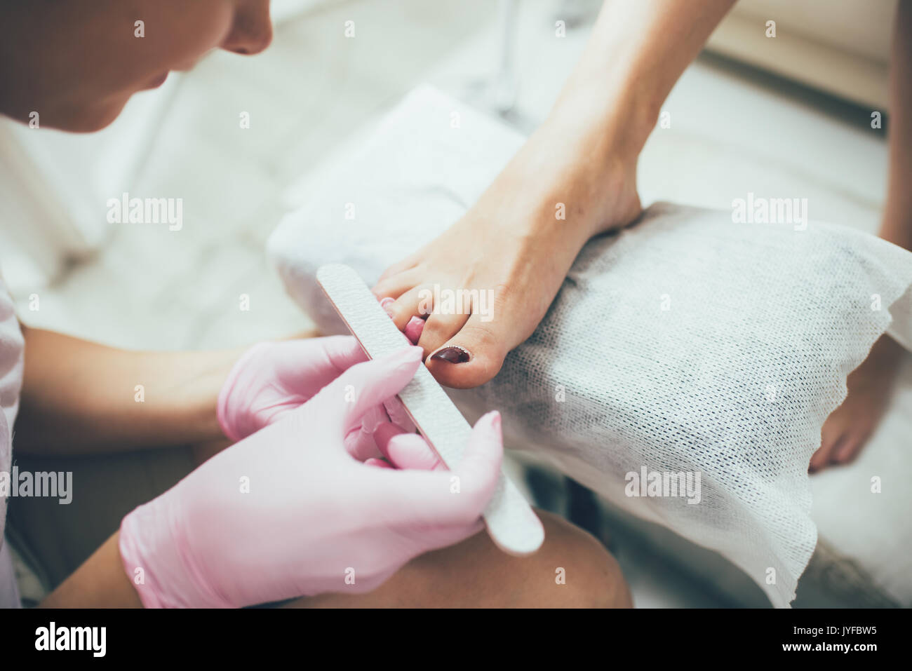 Las manos haciendo una pedicura. Los pies femeninos, salón de belleza, una imagen real Foto de stock