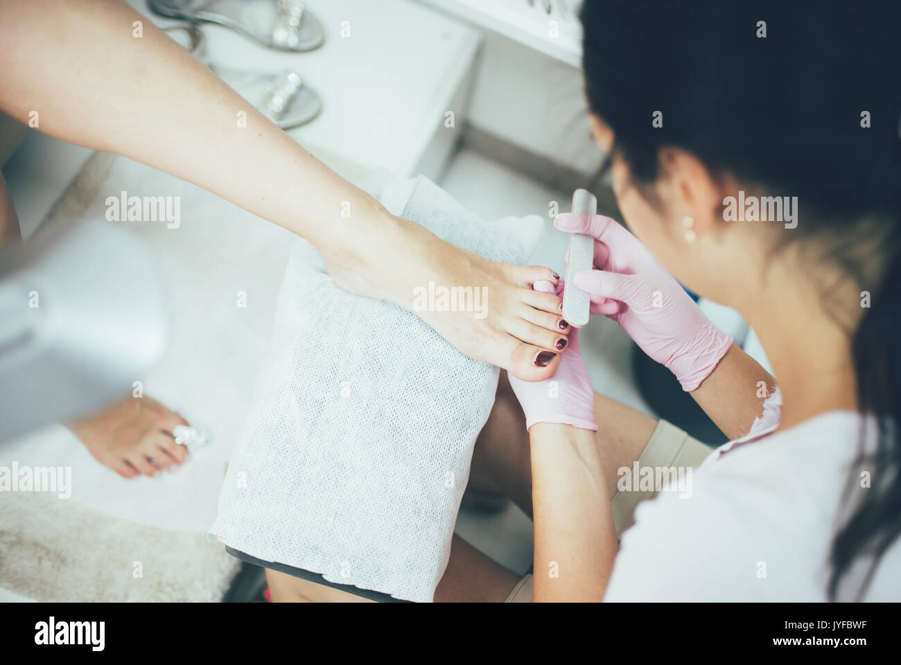 Las manos haciendo una pedicura. Los pies femeninos, salón de belleza, una imagen real Foto de stock